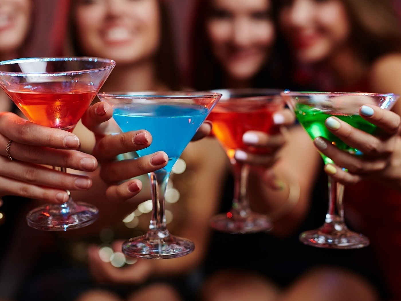Vier junge Frauen stoßen mit alkoholfreien Cocktails an
